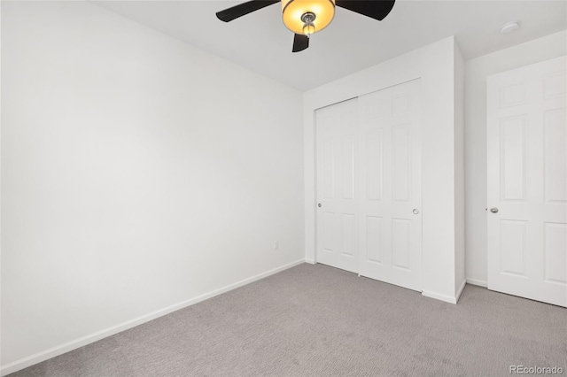 unfurnished bedroom featuring light colored carpet, ceiling fan, and a closet