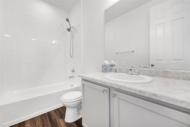 full bathroom featuring toilet, tiled shower / bath combo, vanity, and hardwood / wood-style flooring