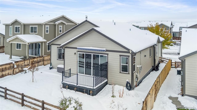 view of snow covered back of property