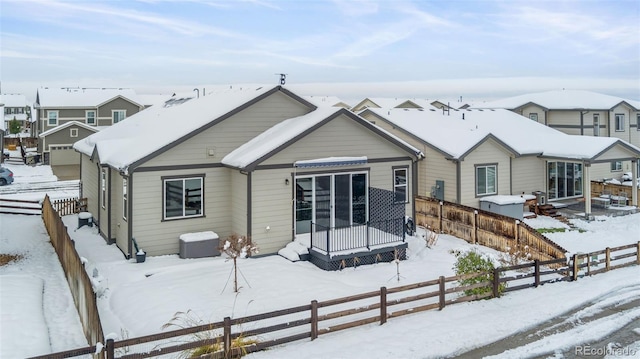 view of snow covered back of property