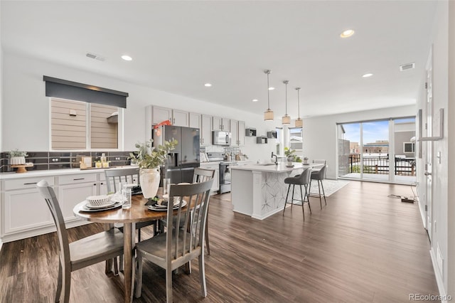 dining area with dark wood-type flooring and sink