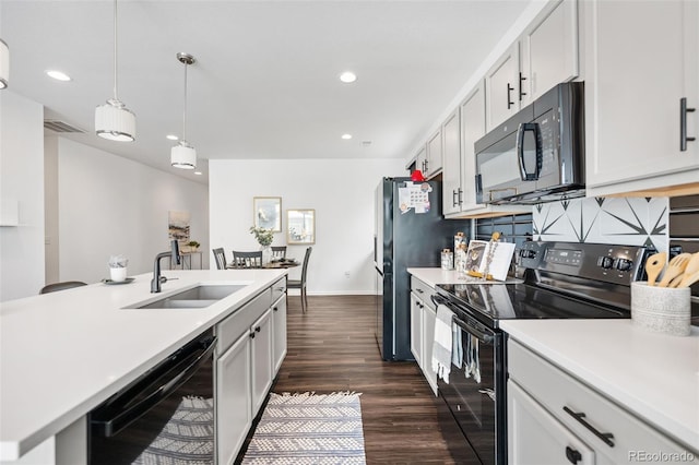 kitchen with white cabinetry, sink, black appliances, dark wood-type flooring, and pendant lighting