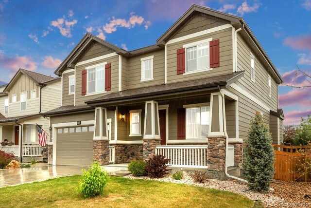 craftsman house featuring a porch, stone siding, a garage, and concrete driveway