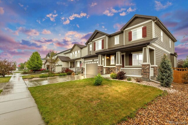 craftsman-style home featuring a porch, stone siding, concrete driveway, and a garage