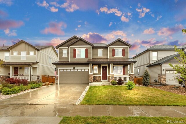 craftsman-style home with a porch, stone siding, driveway, and an attached garage