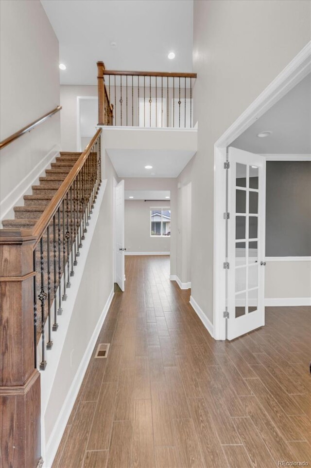 entrance foyer with wood finished floors, stairway, baseboards, and recessed lighting