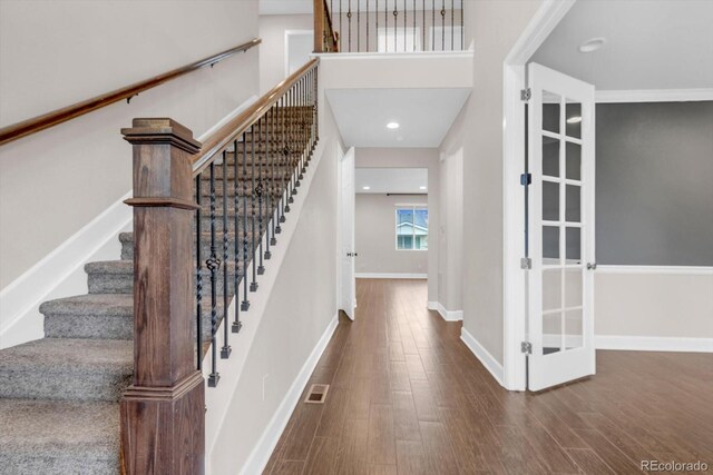 foyer with wood finished floors, stairs, and baseboards