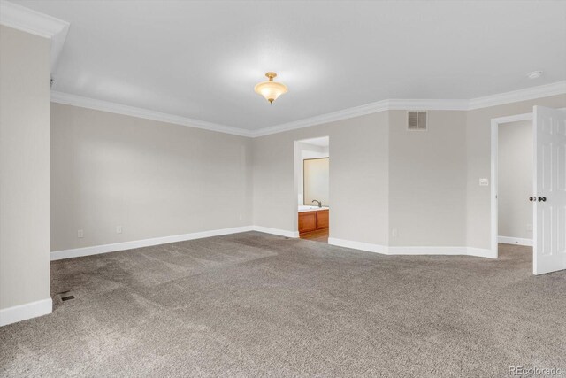 carpeted empty room with crown molding and baseboards