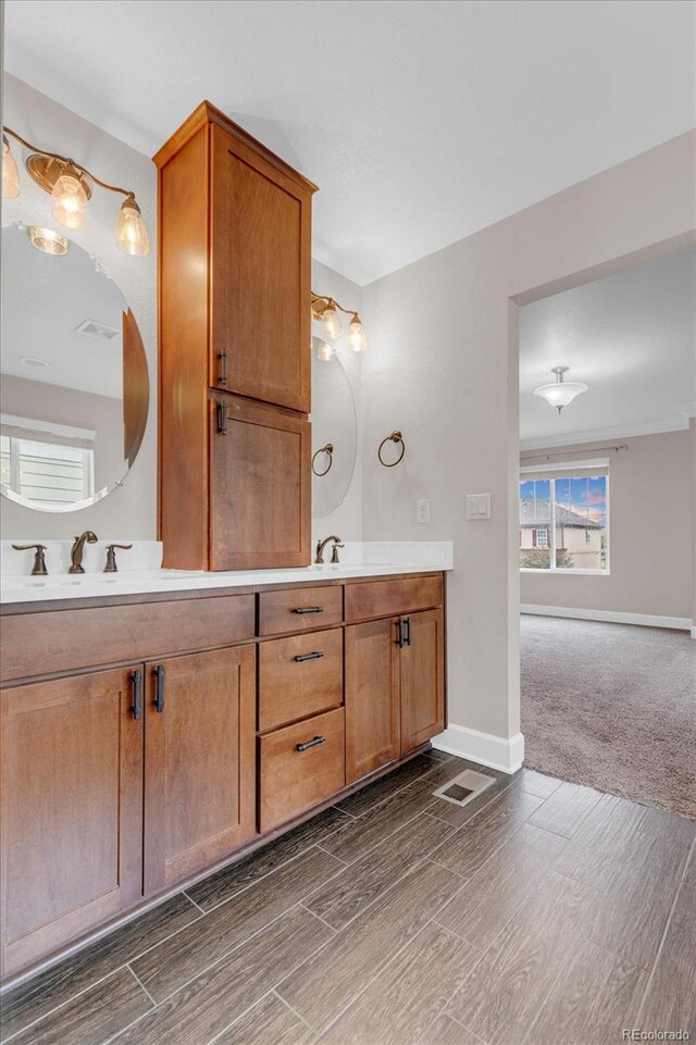 bathroom featuring wood finished floors, double vanity, and baseboards