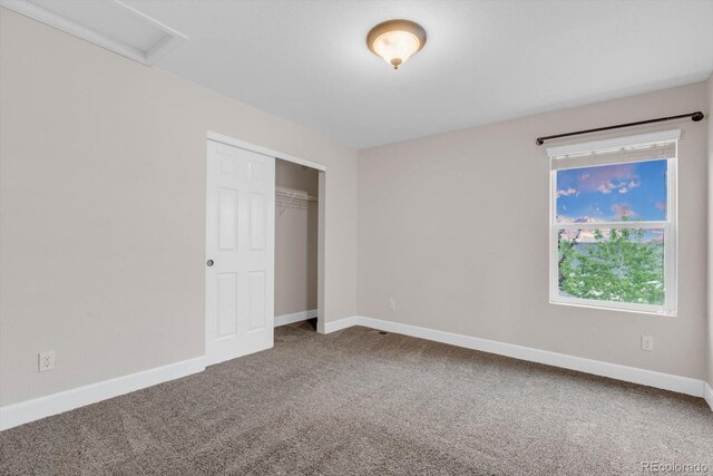 unfurnished bedroom with carpet, baseboards, and a closet