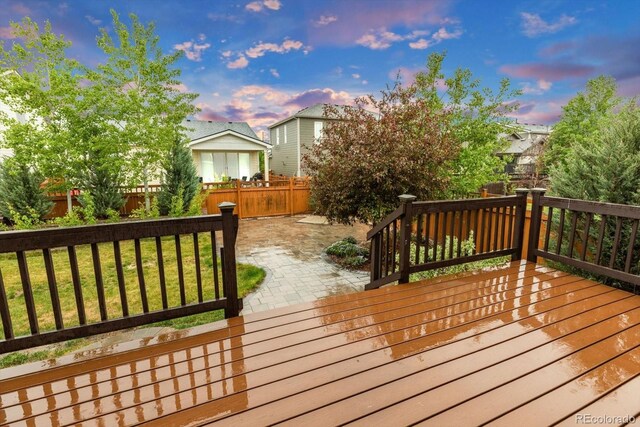 deck at dusk featuring a patio area