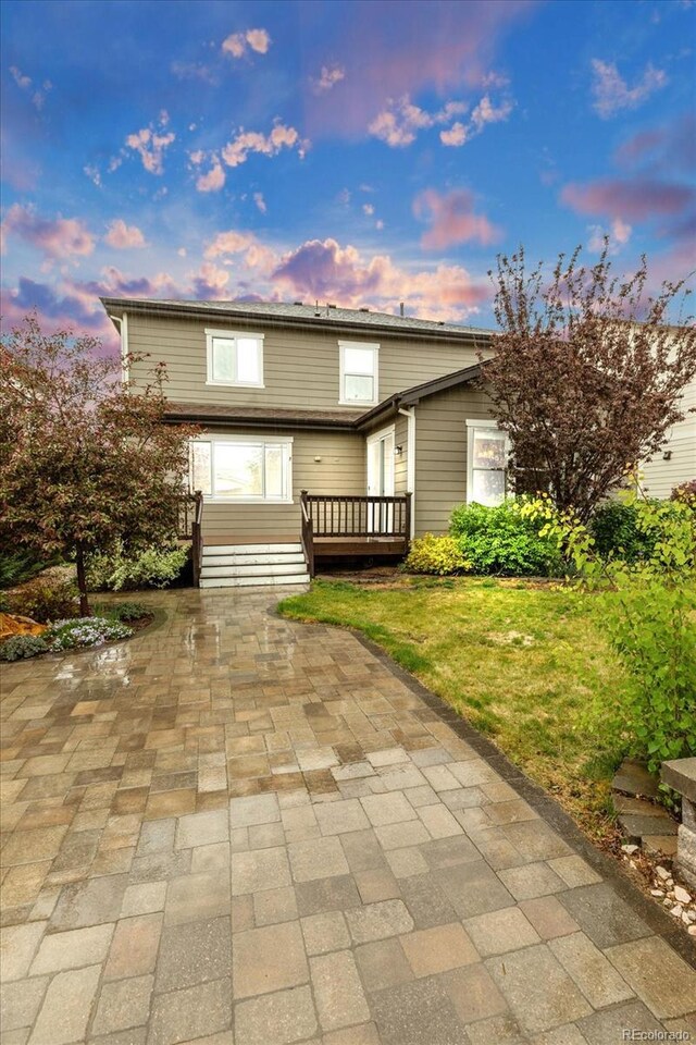 view of front of property with a wooden deck, a patio area, and a front yard