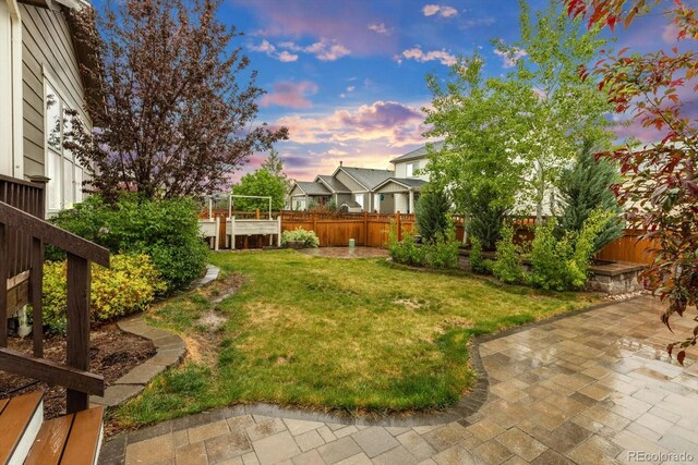 yard at dusk featuring a patio