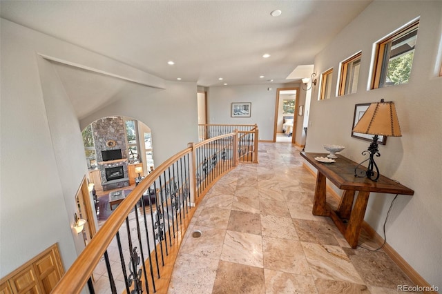 hall featuring plenty of natural light, an upstairs landing, and baseboards