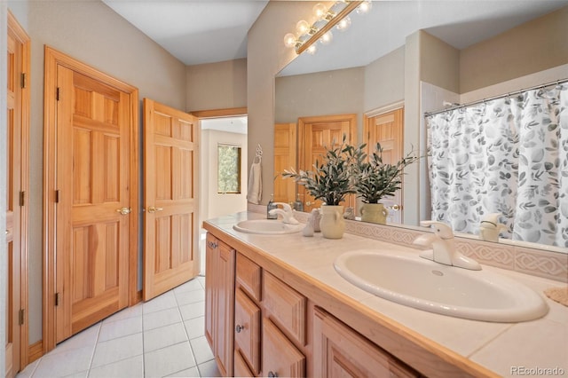 full bath featuring tile patterned flooring, double vanity, and a sink