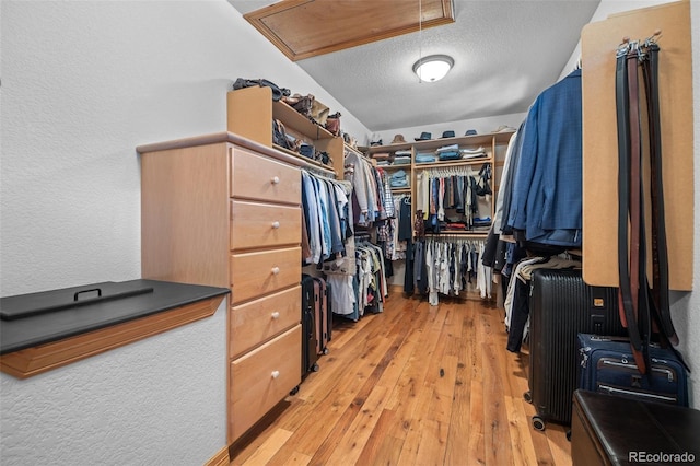 walk in closet featuring light wood-style floors and attic access