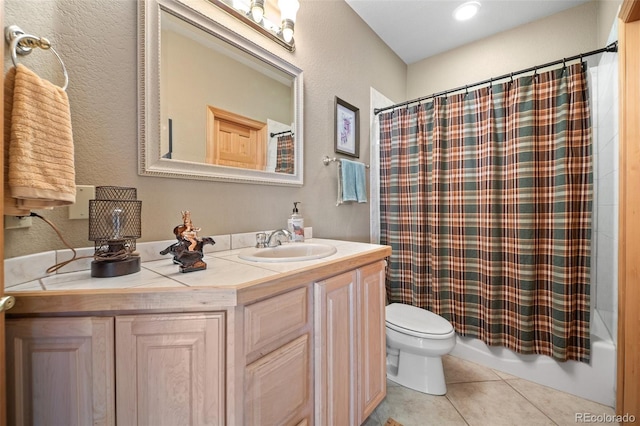full bathroom with toilet, tile patterned floors, vanity, and a textured wall