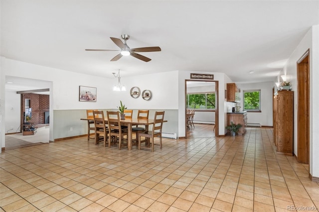 tiled dining space featuring baseboard heating and ceiling fan