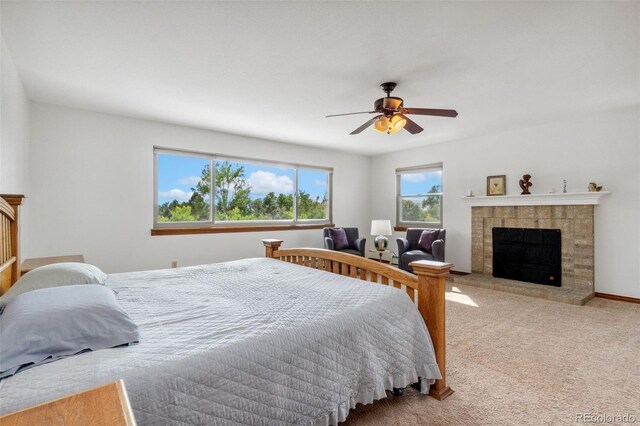 carpeted bedroom with a fireplace and ceiling fan