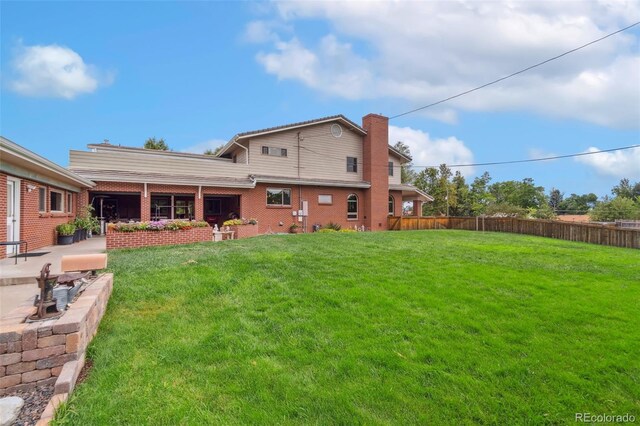 back of property with a patio area and a lawn