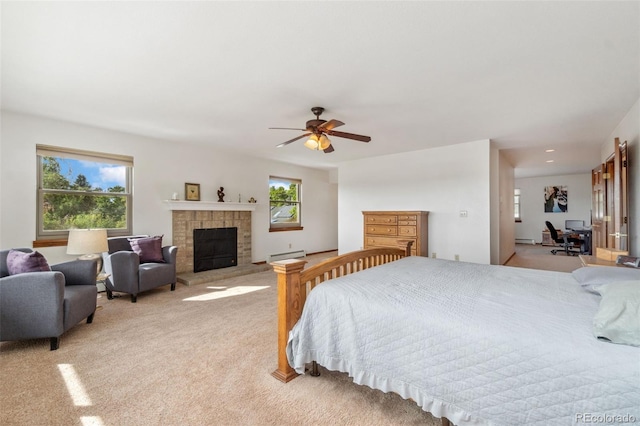 carpeted bedroom with ceiling fan, multiple windows, and baseboard heating