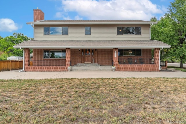 view of front of house with a front yard and covered porch