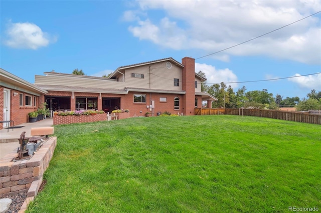 10101 W 72nd Ave, Arvada, CO 80005 - back of house featuring a patio, a chimney, and brick siding
