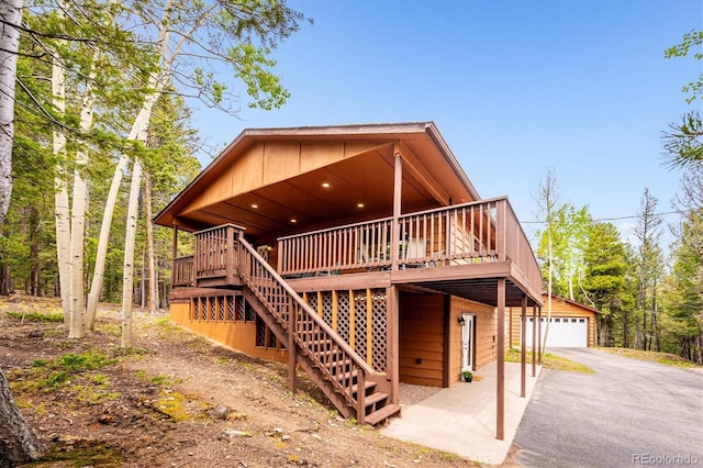 11457 Nancys Dr, Conifer, CO 80433 - rustic home featuring a deck, a detached garage, an outdoor structure, and stairs