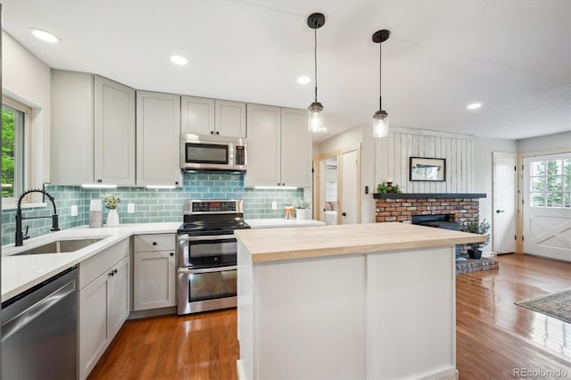 11457 Nancys Dr, Conifer, CO 80433 - kitchen with appliances with stainless steel finishes, decorative backsplash, butcher block counters, wood finished floors, and recessed lighting