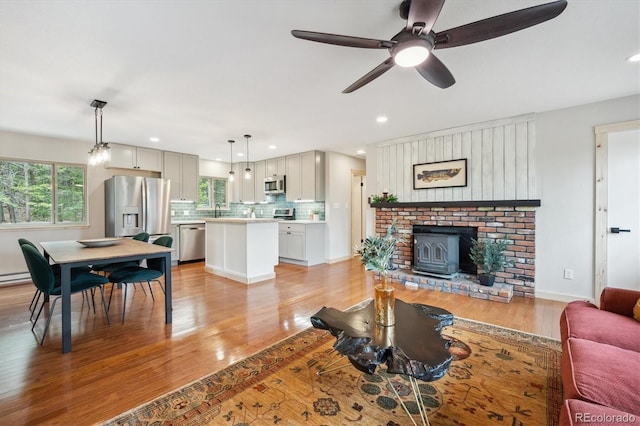 11457 Nancys Dr, Conifer, CO 80433 - living area featuring light wood finished floors, recessed lighting, ceiling fan, and a wood stove