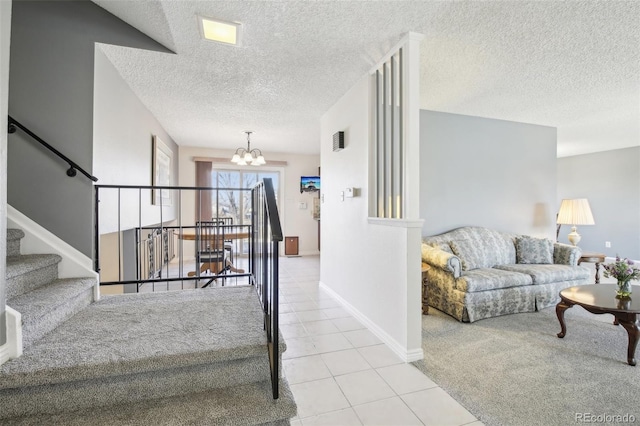 stairway featuring an inviting chandelier, tile patterned flooring, baseboards, and a textured ceiling