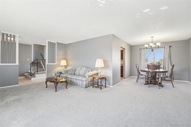 carpeted living room with a notable chandelier, a textured ceiling, baseboards, and stairs