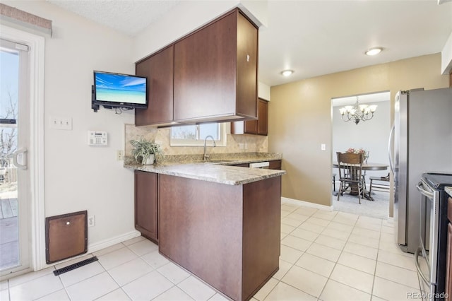 kitchen featuring stainless steel appliances, visible vents, decorative backsplash, a sink, and a peninsula