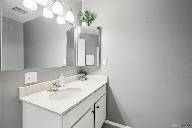 bathroom featuring visible vents, vanity, and baseboards