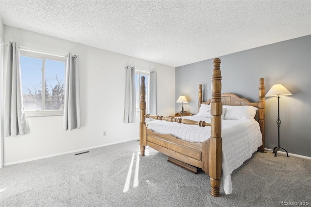 carpeted bedroom with a textured ceiling and baseboards