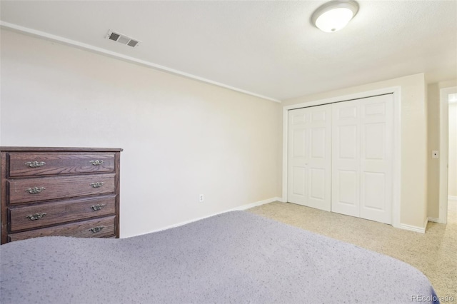 unfurnished bedroom featuring carpet floors, a closet, visible vents, and baseboards