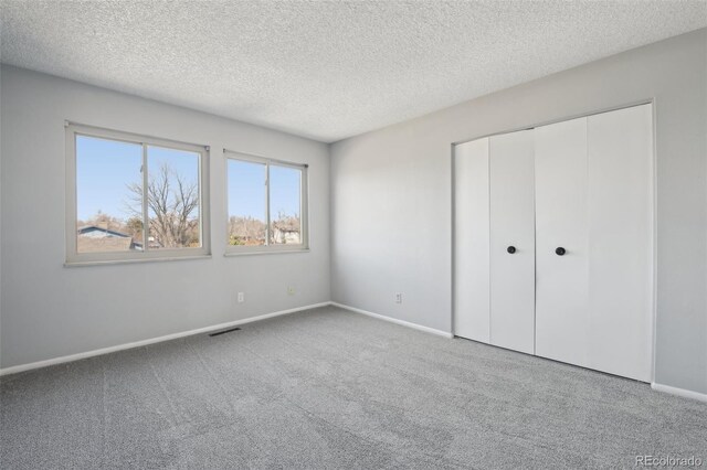 12097 E Mexico Ave, Aurora, CO 80012 - unfurnished bedroom with carpet, a textured ceiling, baseboards, and a closet