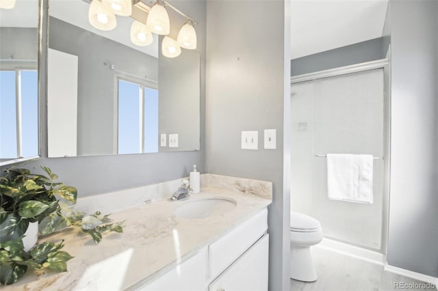 full bath with a shower stall, vanity, and toilet