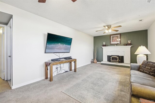12097 E Mexico Ave, Aurora, CO 80012 - living room featuring a ceiling fan, carpet flooring, a fireplace with raised hearth, and a textured ceiling
