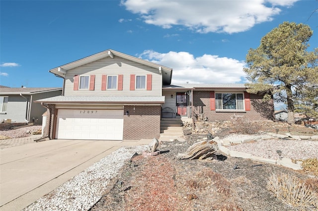split level home with concrete driveway, brick siding, and a garage