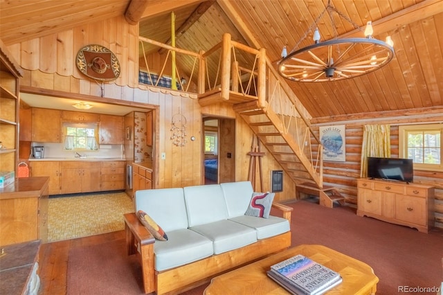 living room with log walls, stairs, beam ceiling, high vaulted ceiling, and wooden ceiling