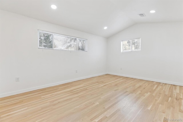 empty room with visible vents, baseboards, light wood-type flooring, vaulted ceiling, and recessed lighting