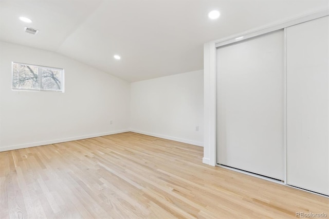 unfurnished room with vaulted ceiling, recessed lighting, light wood-style floors, and visible vents