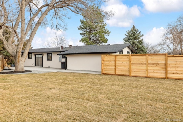 back of house with a patio, fence, a yard, a shingled roof, and stucco siding