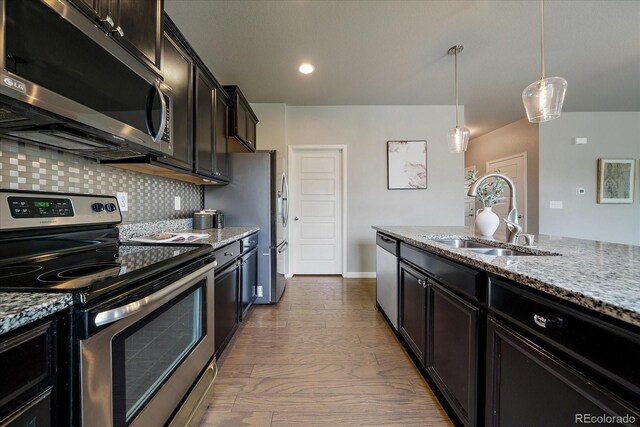 1181 W 170th Ave, Broomfield, CO 80023 - kitchen with appliances with stainless steel finishes, a sink, light stone countertops, tasteful backsplash, and pendant lighting