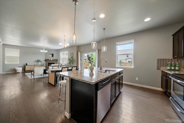 1181 W 170th Ave, Broomfield, CO 80023 - kitchen featuring appliances with stainless steel finishes, a sink, a chandelier, dark wood-style floors, and baseboards