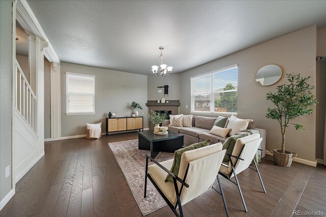 1181 W 170th Ave, Broomfield, CO 80023 - living room with baseboards, a chandelier, dark wood-style flooring, and a fireplace