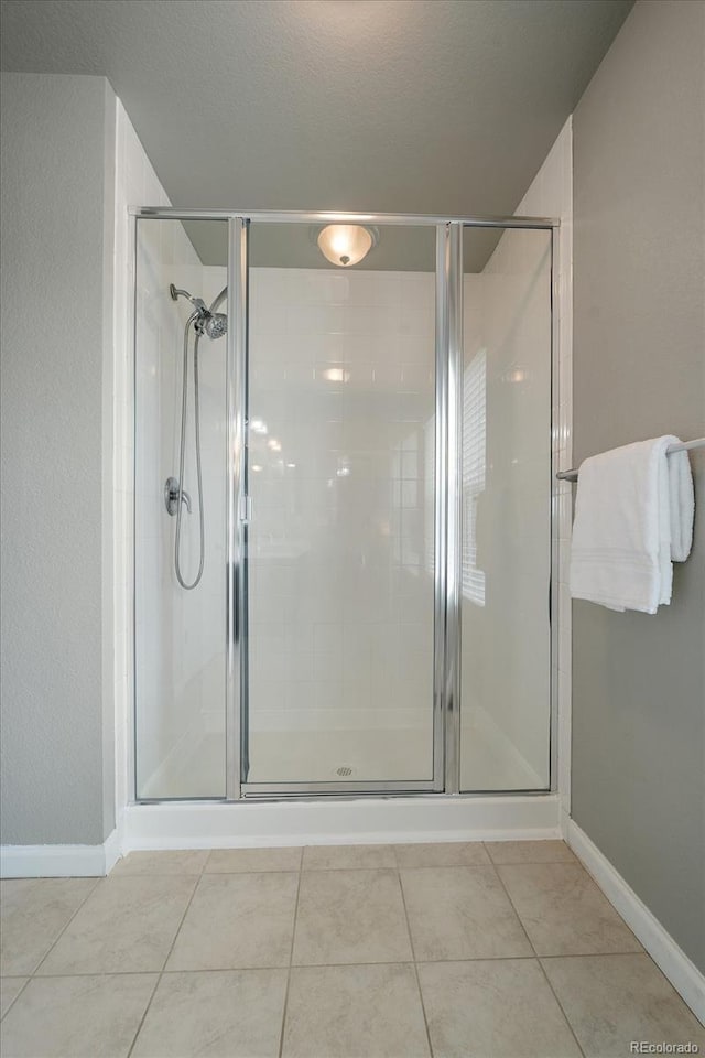 1181 W 170th Ave, Broomfield, CO 80023 - bathroom with a stall shower, tile patterned flooring, and baseboards