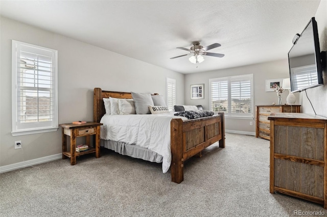 carpeted bedroom featuring baseboards and a ceiling fan