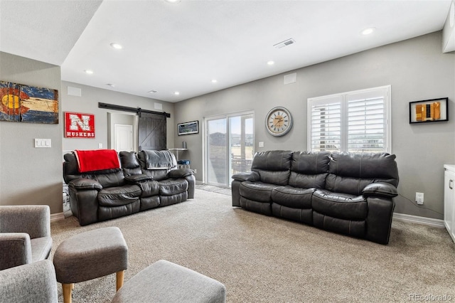 living room with baseboards, visible vents, a barn door, and carpet flooring